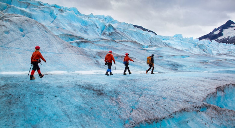 Four people walking on Mendenhall Glacier, Alaska, USA