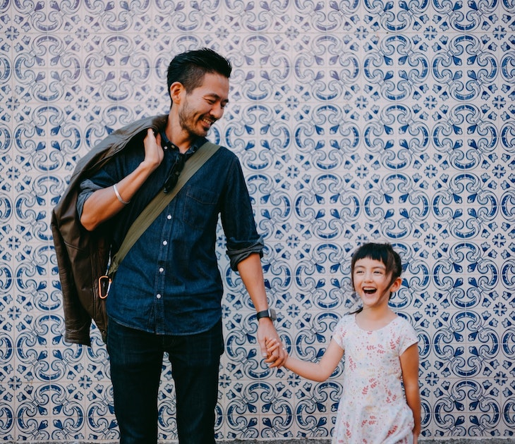 Japanese father and his preschool mixed race daughter on street of Portugal with azulejo tile wall