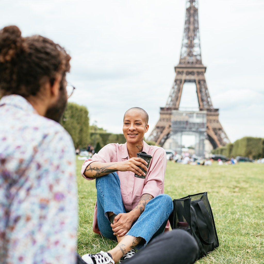 People enjoying relaxing or working near Eiffel tower in Paris, France