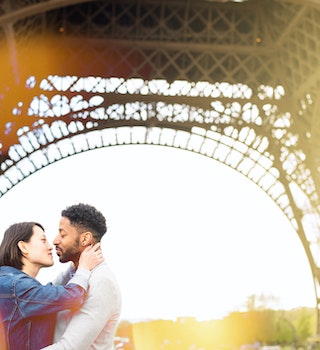 Multi-racial love in Paris - Chinese and African origins. Romantic sunset moment at the Eiffel Tower, Paris, France.