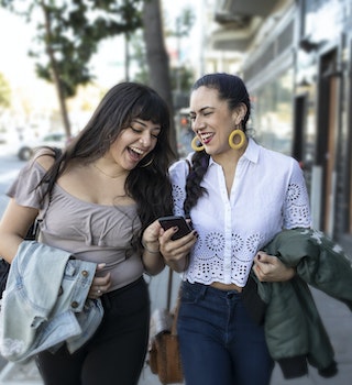 In San Francisco's Mission District, these two millennial generation best friends (lovers, business partners, sisters?) are sharing a moment of laughter while looking at a smartphone. They're leaning close to each other and are confident about where they're going whether to work, to play, to lunch, or to a high-stakes pitch meeting. Their smiles show that they just learned something amazing and they are fully engaged with the moment and each other.
1092349604
togetherness, people, young adult, affectionate, 20-24 years, young couple, enjoyment, lifestyles, cheerful, couple - relationship, friendship, happiness, fun, joy, waist up, carefree, girlfriend, leisure activity, bonding, day, mission district, walking, sidewalk, smart phone, smart casual, technology, skin, earring, latin american and hispanic ethnicity, black hair, braided hair, lace - textile, body positive, portable information device, mobile phone, laughing, smiling, discussion, communication, jeans, shoulder bag, touching, identity, confidence, city life, san francisco - california, the way forward, reflection, attitude, positive emotion, Two People
Two Latina women walking through the Mission District in San Francisco laughing together as check a smartphone