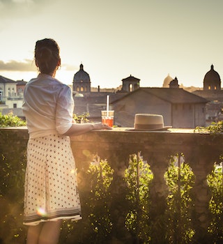 Young woman tourist fashion white dress with spritz cocktail in front of panoramic view of Rome cityscape from campidoglio terrace at sunset. Landmarks, domes of Rome, Italy.
1207032121