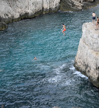 Young people jump from cliffs at the calanque de Sugiton in the Parc national des calanques in Marseille, southern France, on June 24, 2022. - Reservations for access to two creeks in Marseille from June 26, 2022 opened on June 23, 2022 on the website of the Calanques National Park, which is limiting the number of visitors to these fragile Mediterranean natural areas to 400 per day this summer, a first in France. (Photo by Nicolas TUCAT / AFP) (Photo by NICOLAS TUCAT/AFP via Getty Images)
1241498129
Horizontal