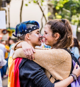 Annual gay pride march held in the streets of the city of Buenos Aires in November 2017. Young couple of two lesbian women hugged wanting to kiss each other in the middle of the crowd.