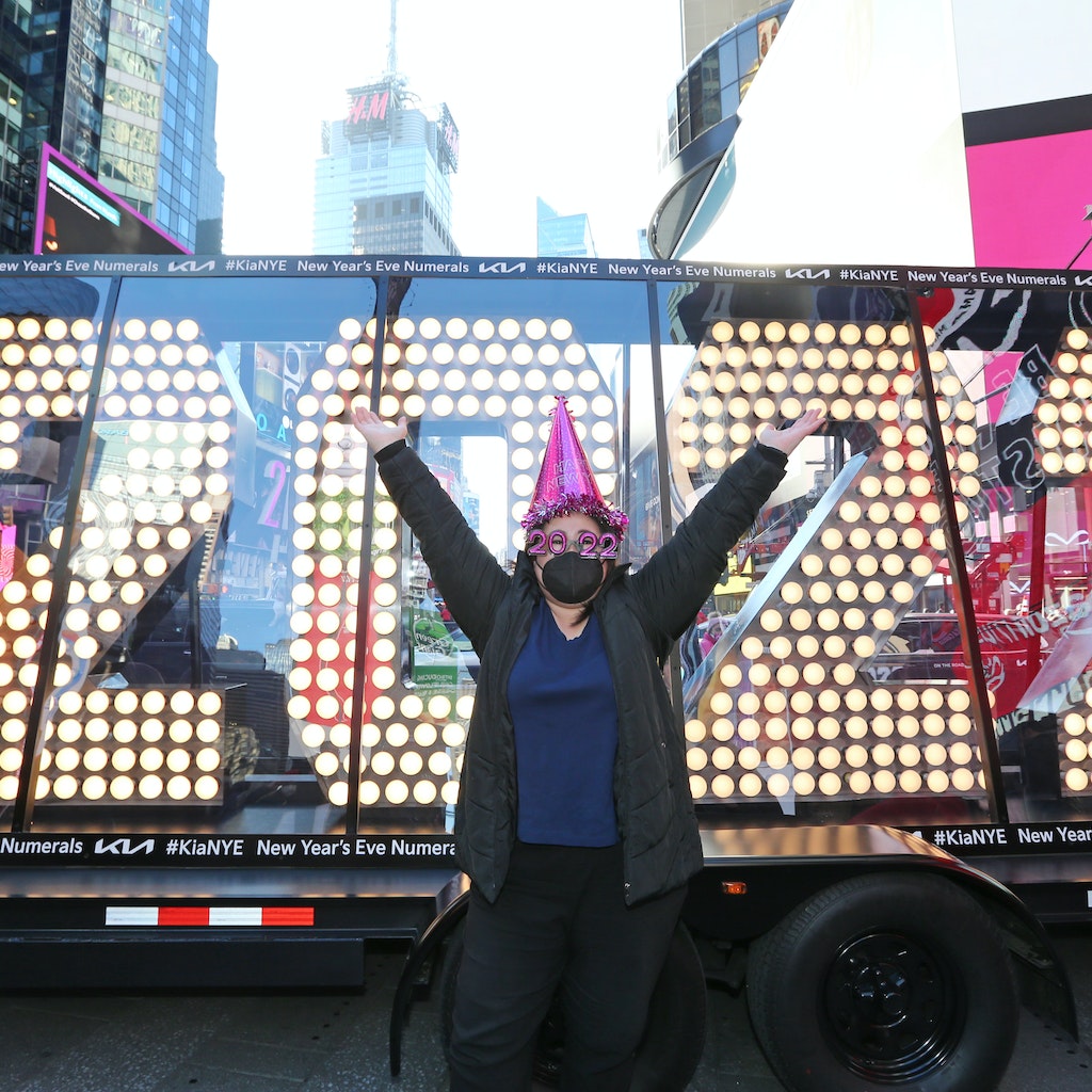 NEW YORK, NEW YORK - DECEMBER 20: A person wearing festive new year's hat and glasses poses at the 2022 New Year's Eve numerals as they arrive in Times Square on December 20, 2021 in New York City. (Photo by Rob Kim/Getty Images)