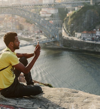 Traveler man doing photo on mobile phone. Porto, famous iron bridge and Douro rive on background ; Shutterstock ID 1086295274; your: Claire naylor; gl: 65050; netsuite: Online ed; full: Portugal best places
1086295274