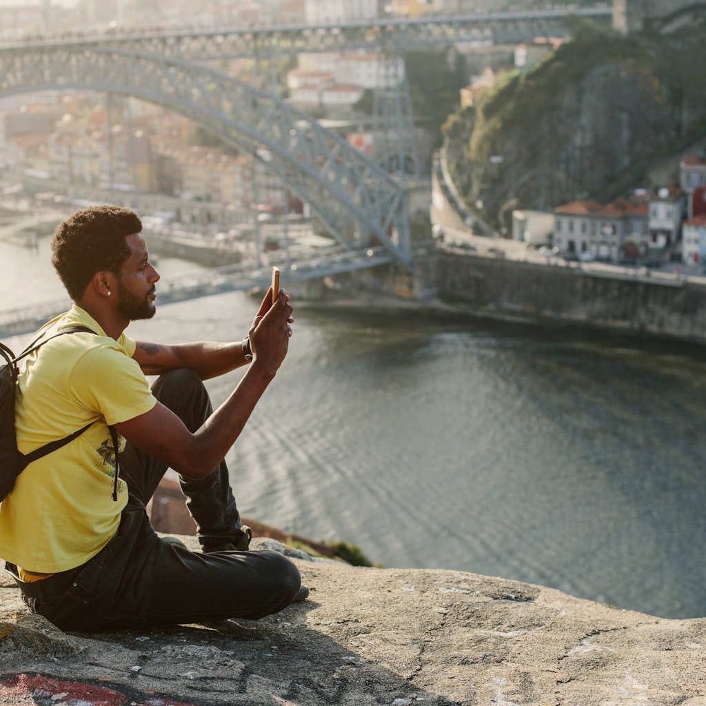 Traveler man doing photo on mobile phone. Porto, famous iron bridge and Douro rive on background ; Shutterstock ID 1086295274; your: Claire naylor; gl: 65050; netsuite: Online ed; full: Portugal best places
1086295274