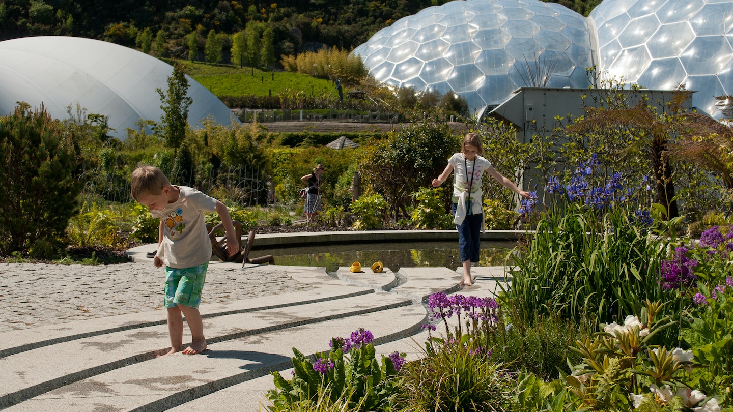 Eden Project, Cornwall, UK - 06/04/2013 - biomes and landscape with children in the foreground.; Shutterstock ID 1352482403; Your name (First / Last): Claire Naylor; GL account no.: 65050  ; Netsuite department name: Online Editorial; Full Product or Project name including edition: England with kids