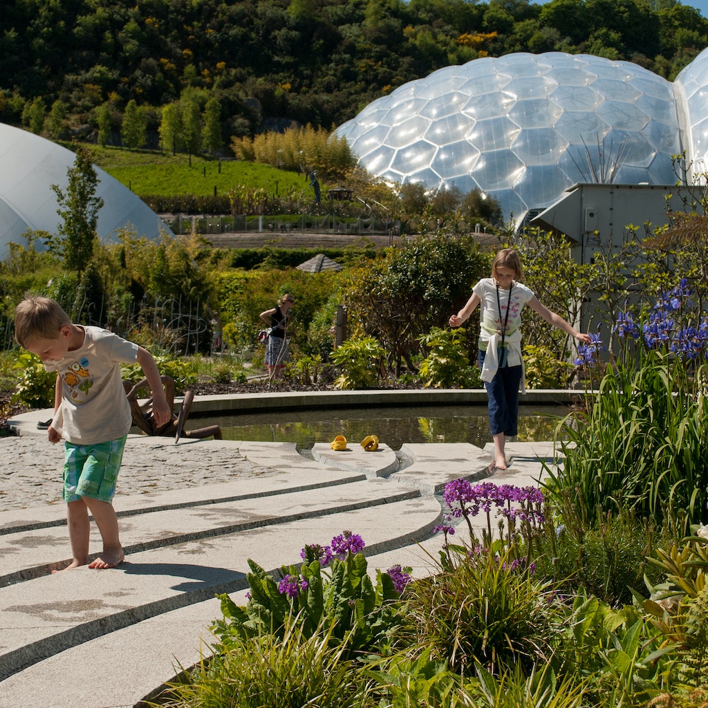 Eden Project, Cornwall, UK - 06/04/2013 - biomes and landscape with children in the foreground.; Shutterstock ID 1352482403; Your name (First / Last): Claire Naylor; GL account no.: 65050  ; Netsuite department name: Online Editorial; Full Product or Project name including edition: England with kids