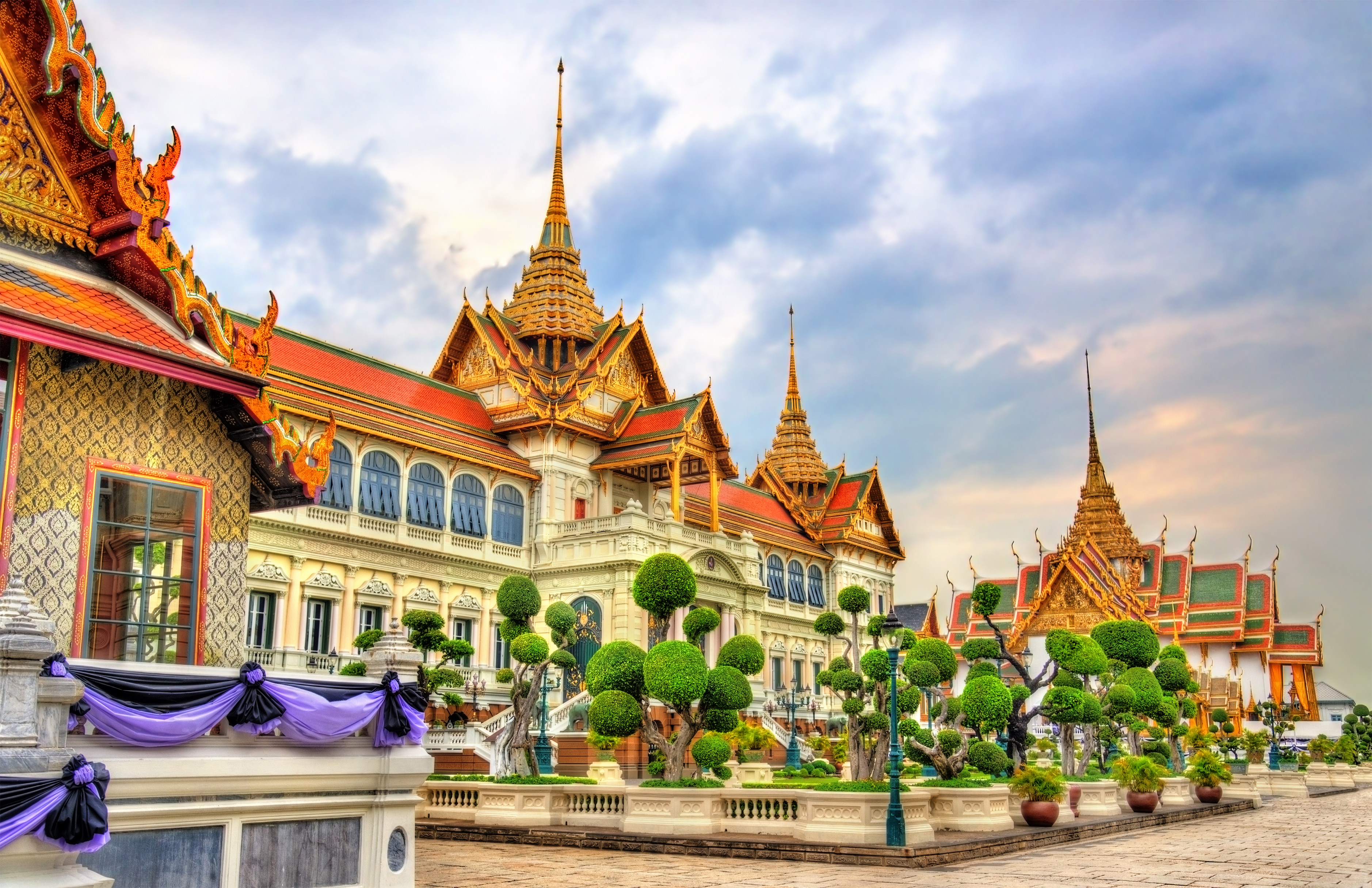 The Chakri Mahaprasat (Grand Palace Hall) at Grand Palace of Thailand in Bangkok with its European architecture at the bottom and a mon·dòp (a layered, heavily ornamented spire) atop each wing.