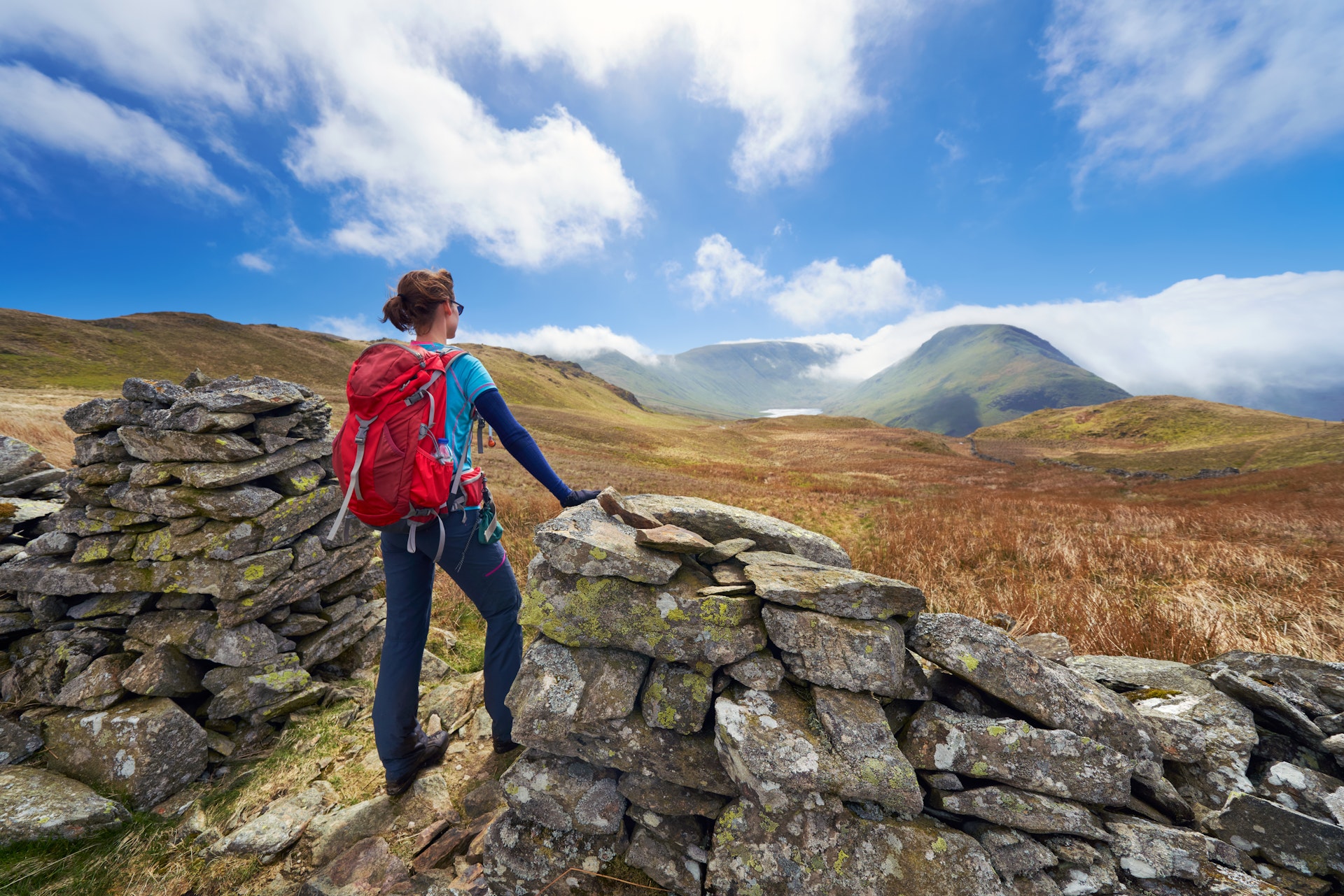 A female hiker taking in the mountain views of Hayeswater, Lake District, UK 